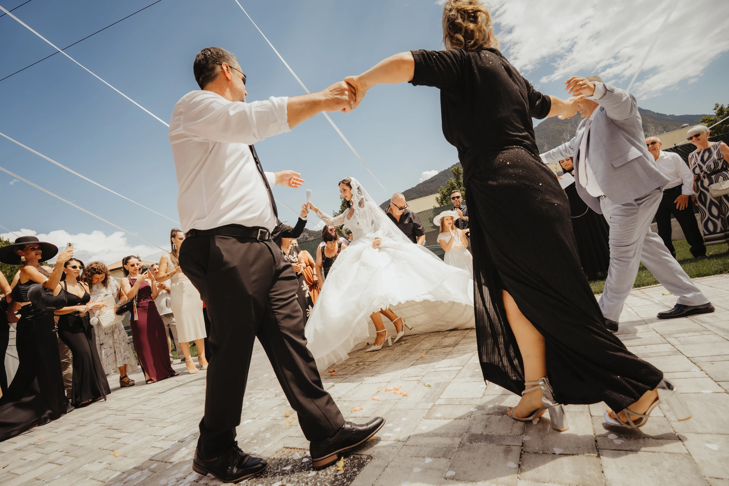 Newlyweds dancing with guests at an outdoor wedding