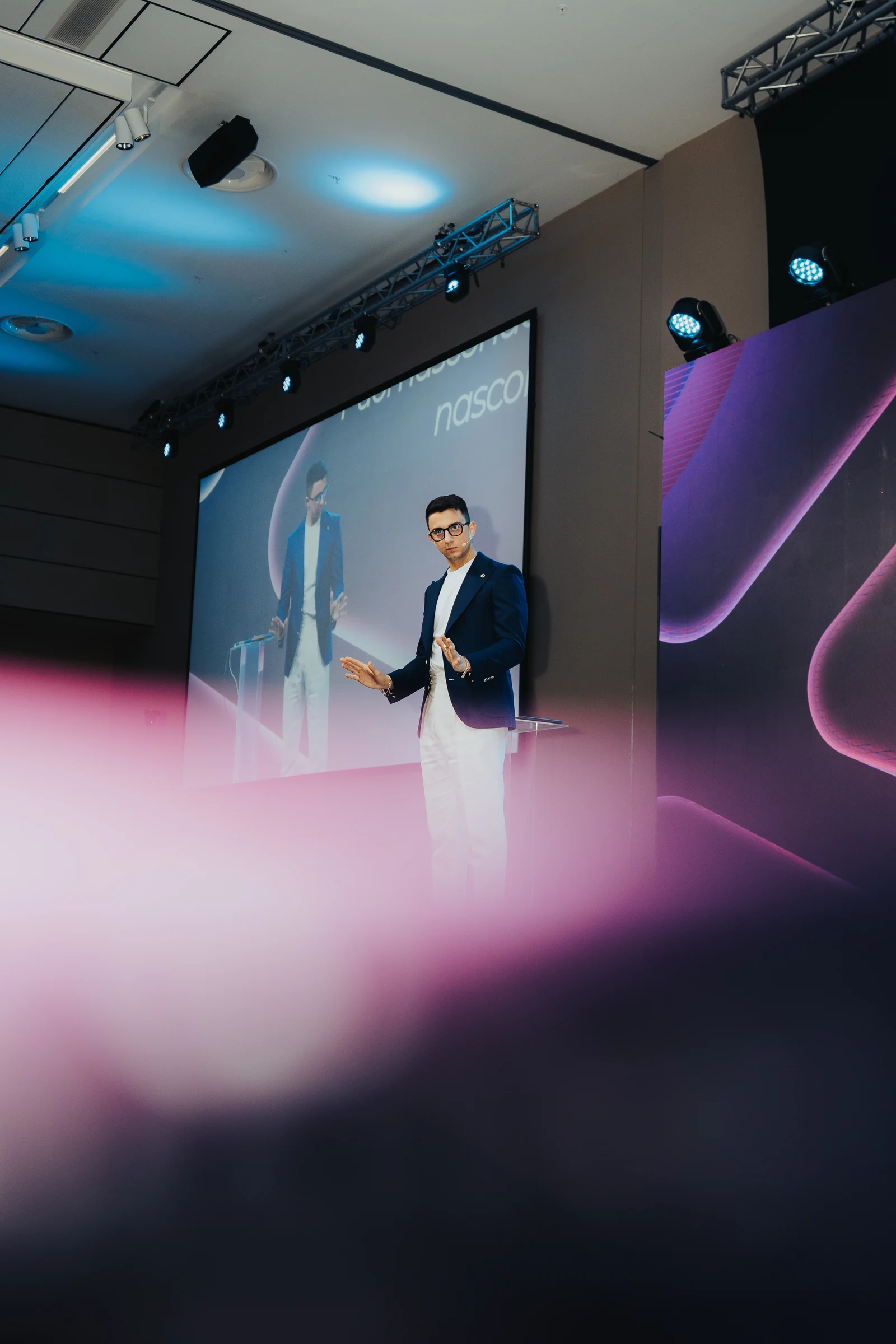 Male speaker presenting on a corporate stage