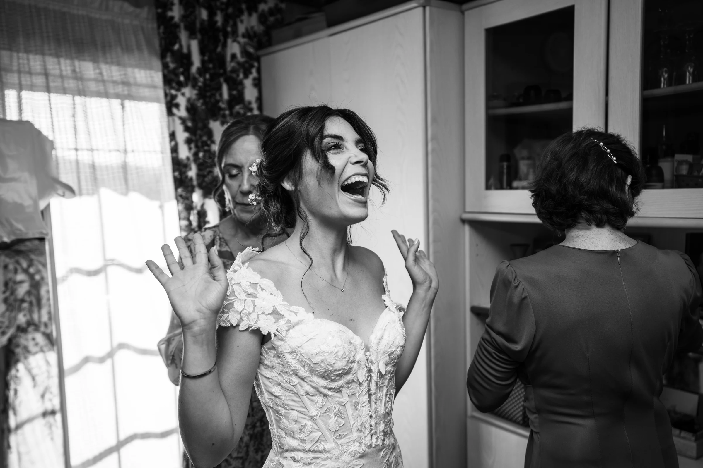 Smiling bride photographed backstage in black and white