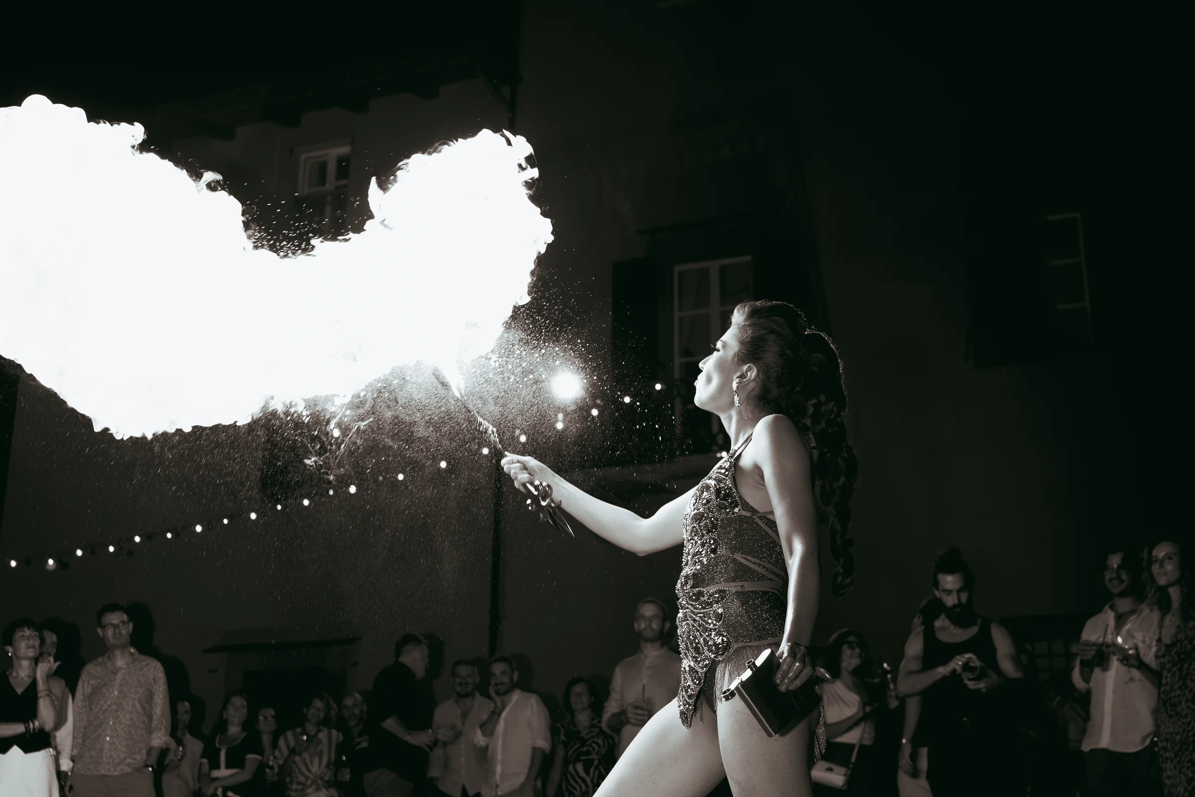 Fire performer blowing flames at an outdoor castle event