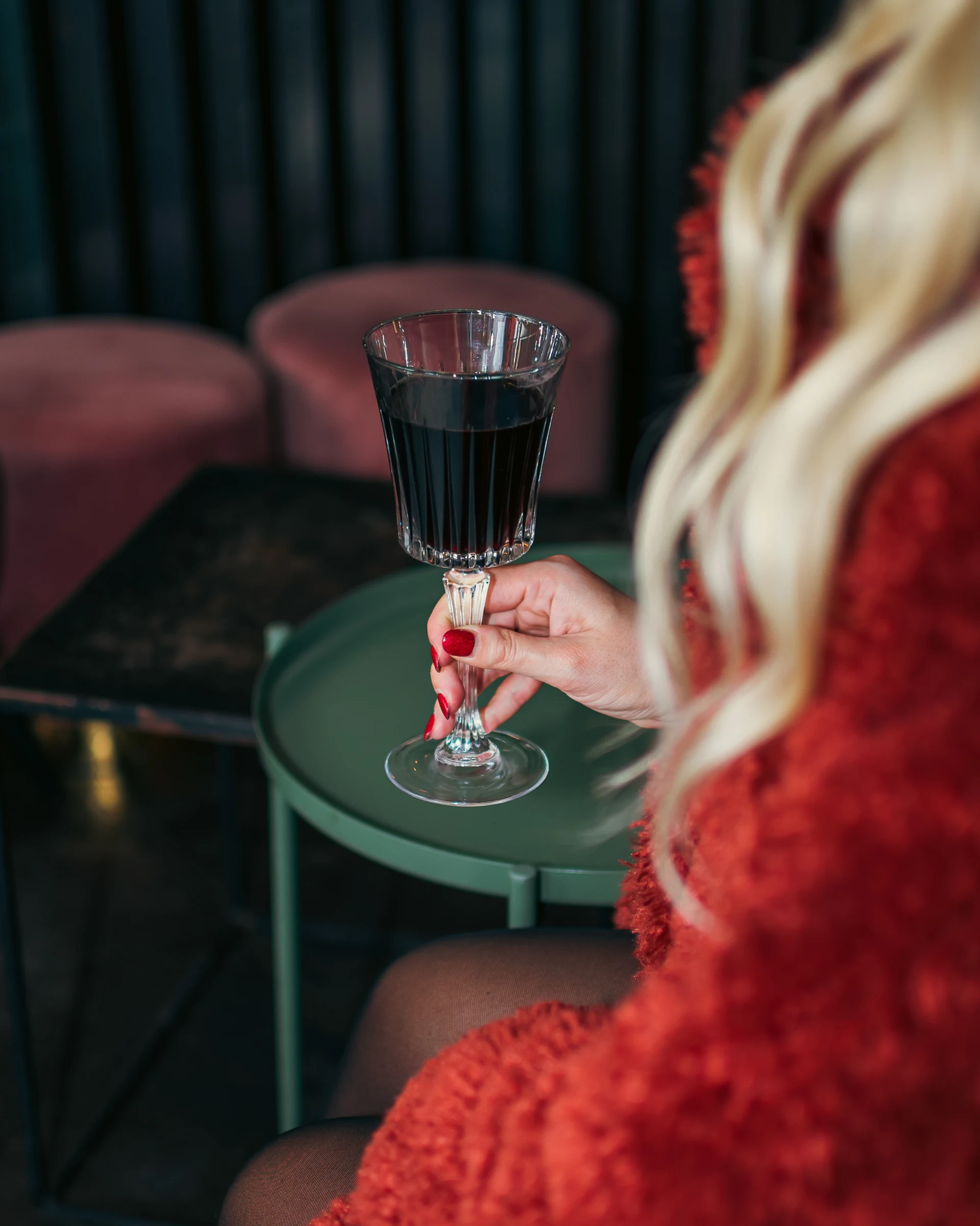 Guest holding a glass of red wine in a lounge