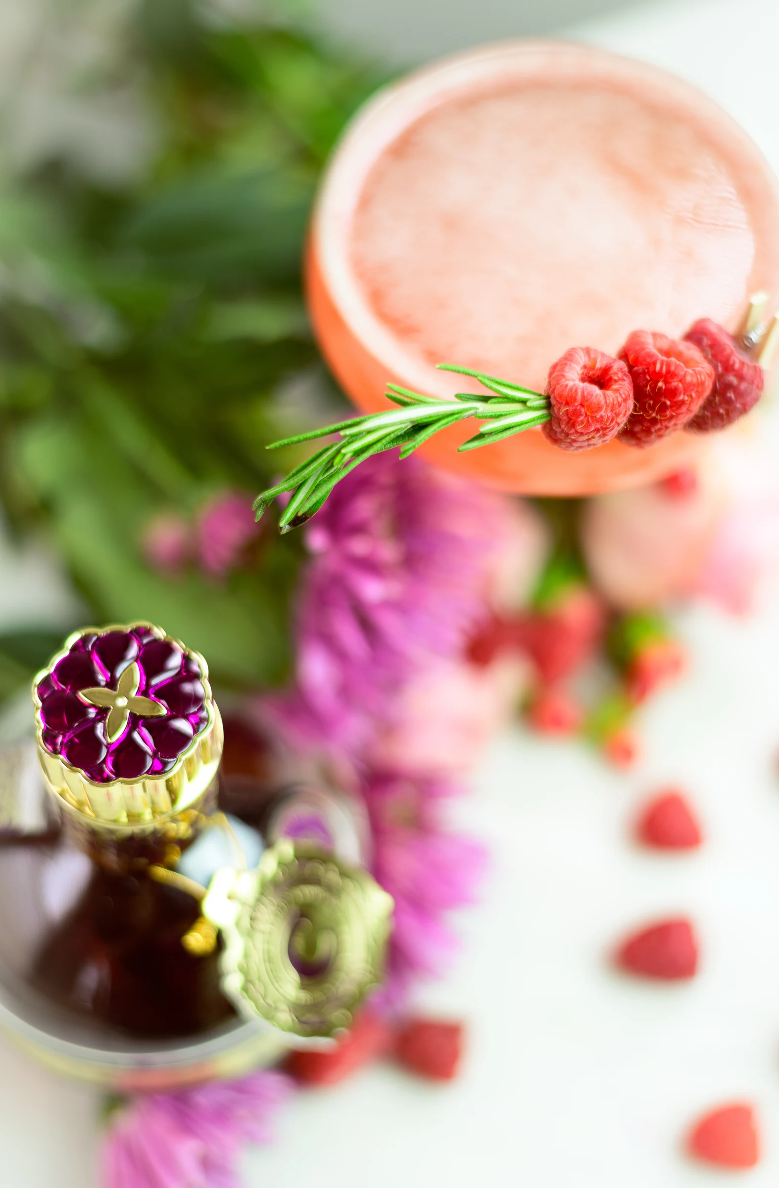 Pink cocktail paired with floral petit fours