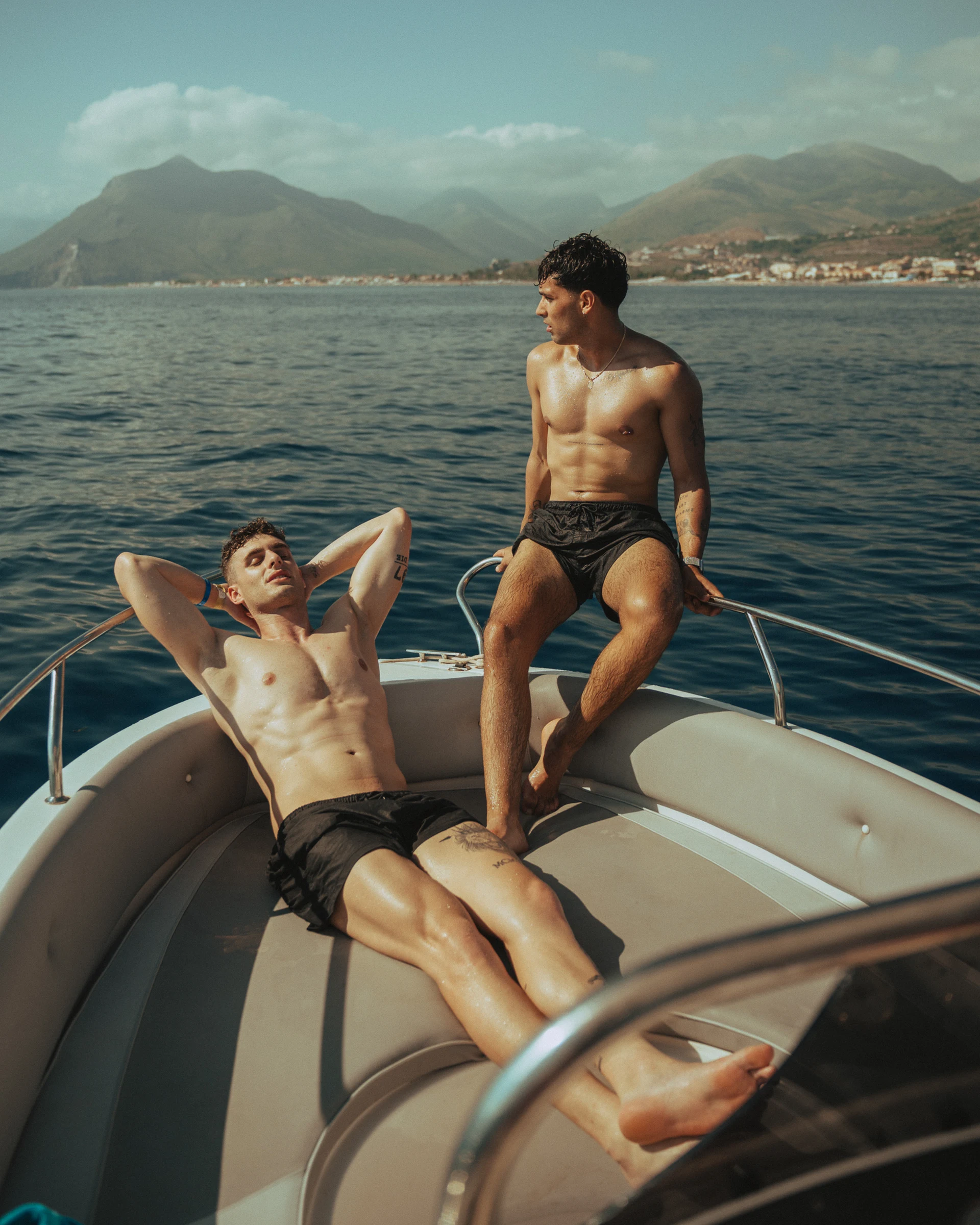 Two men photographed aboard a boat on a lake