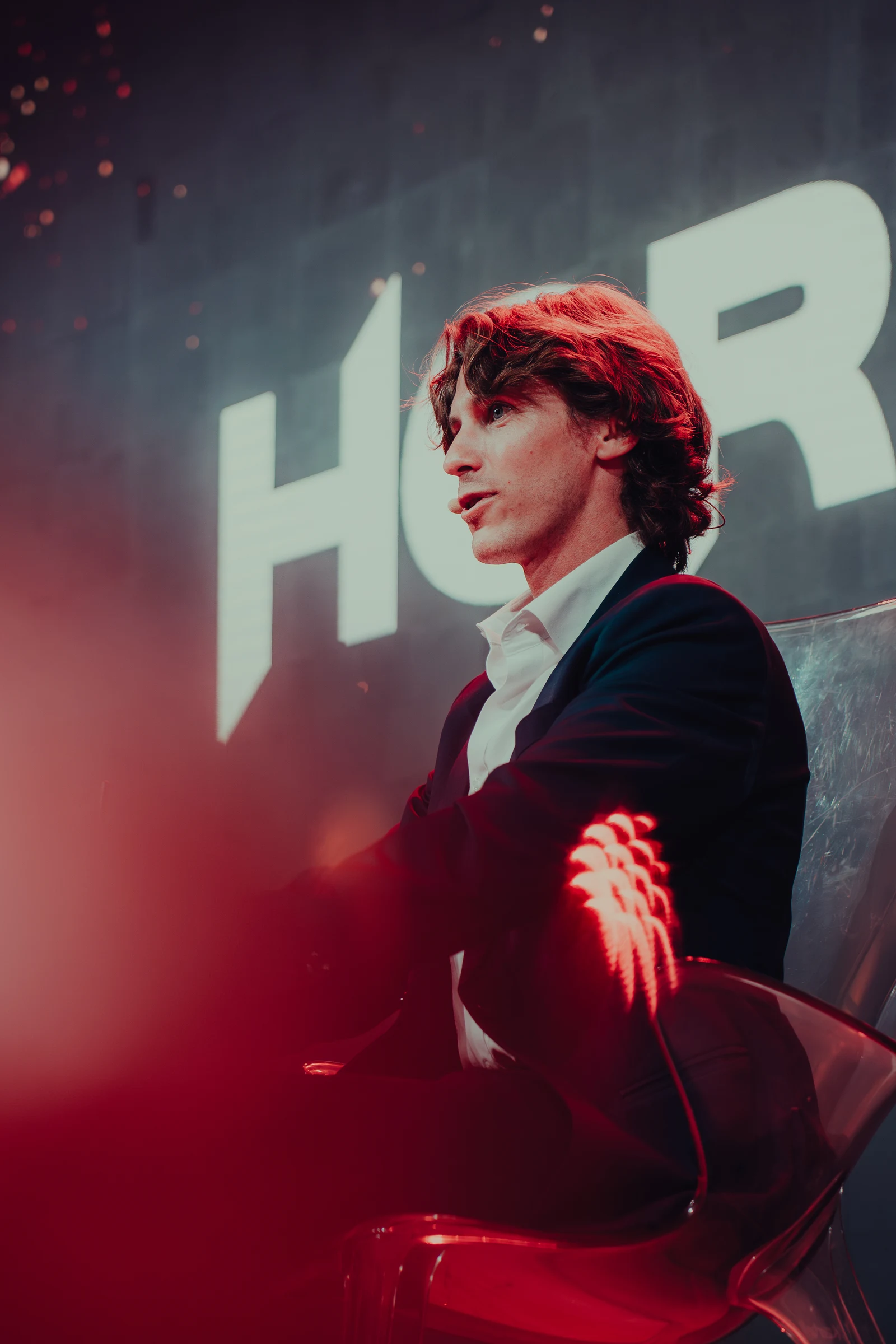 Male portrait in a suit under red stage lighting