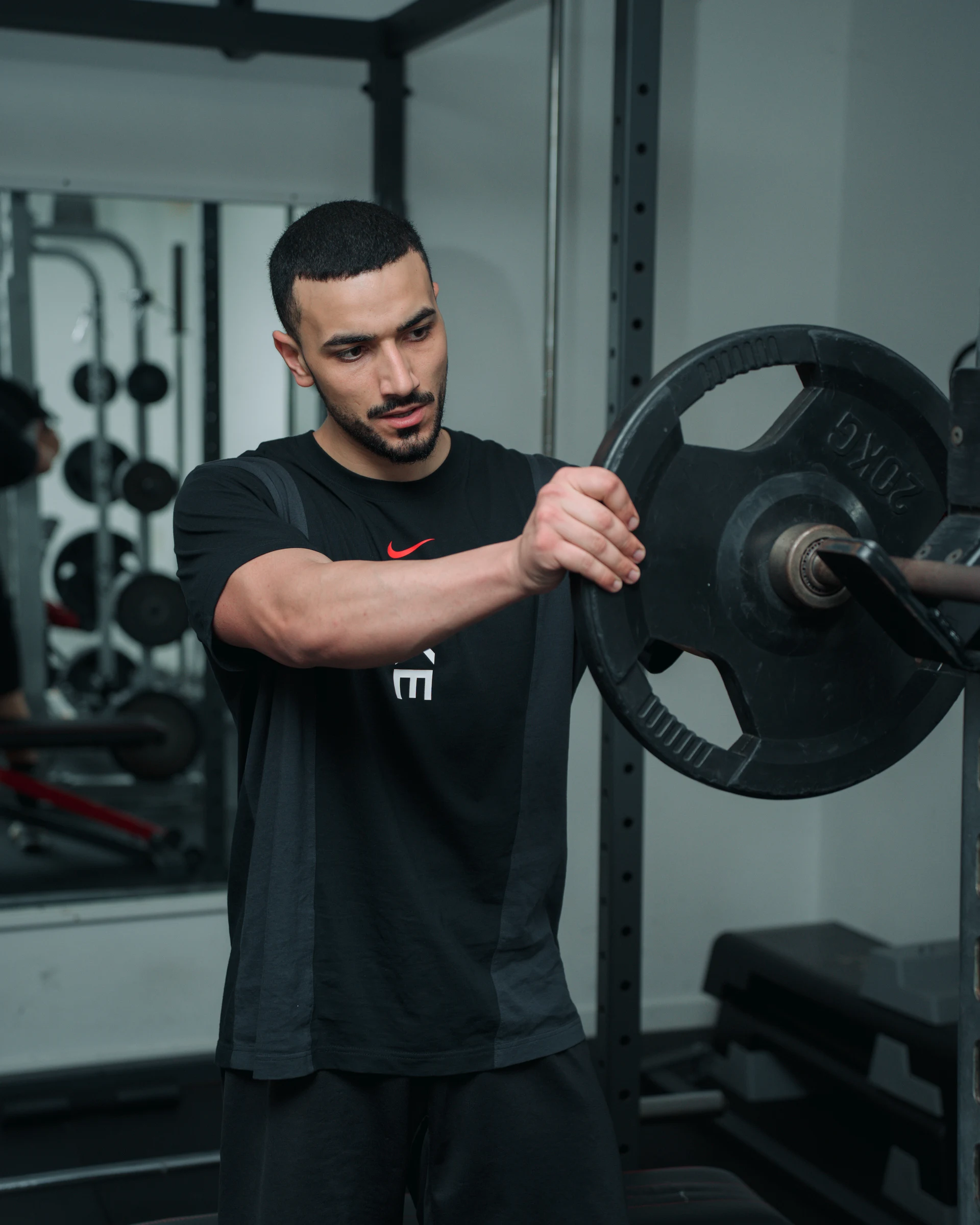 Fitness coach handling a weight plate in a gym