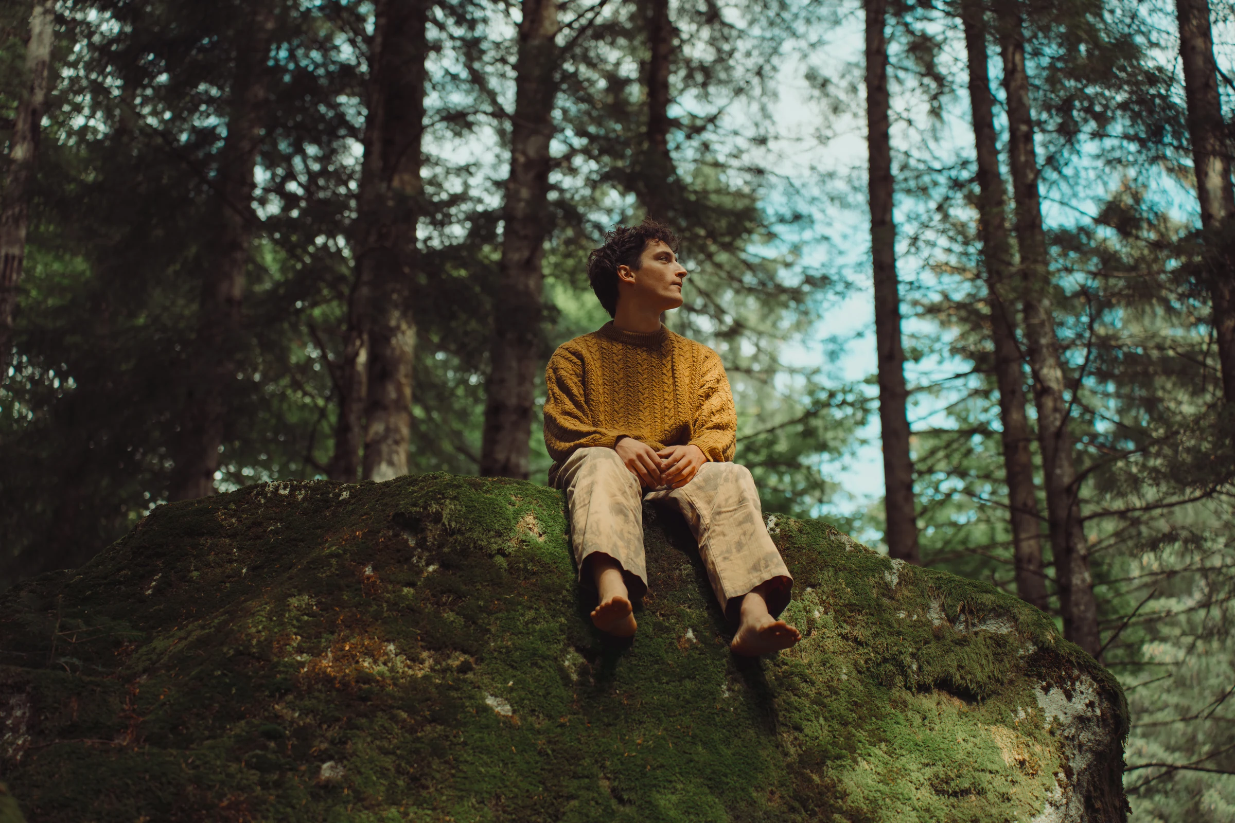 Environmental portrait of a man seated in a forest