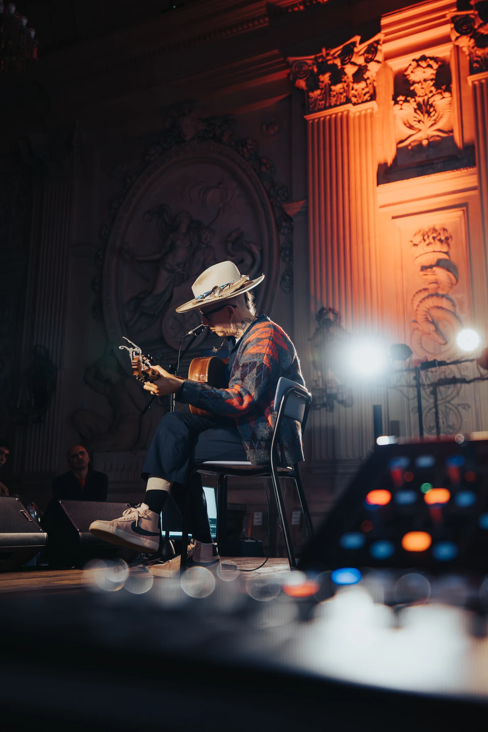 Musician photographed on a stage lit in orange