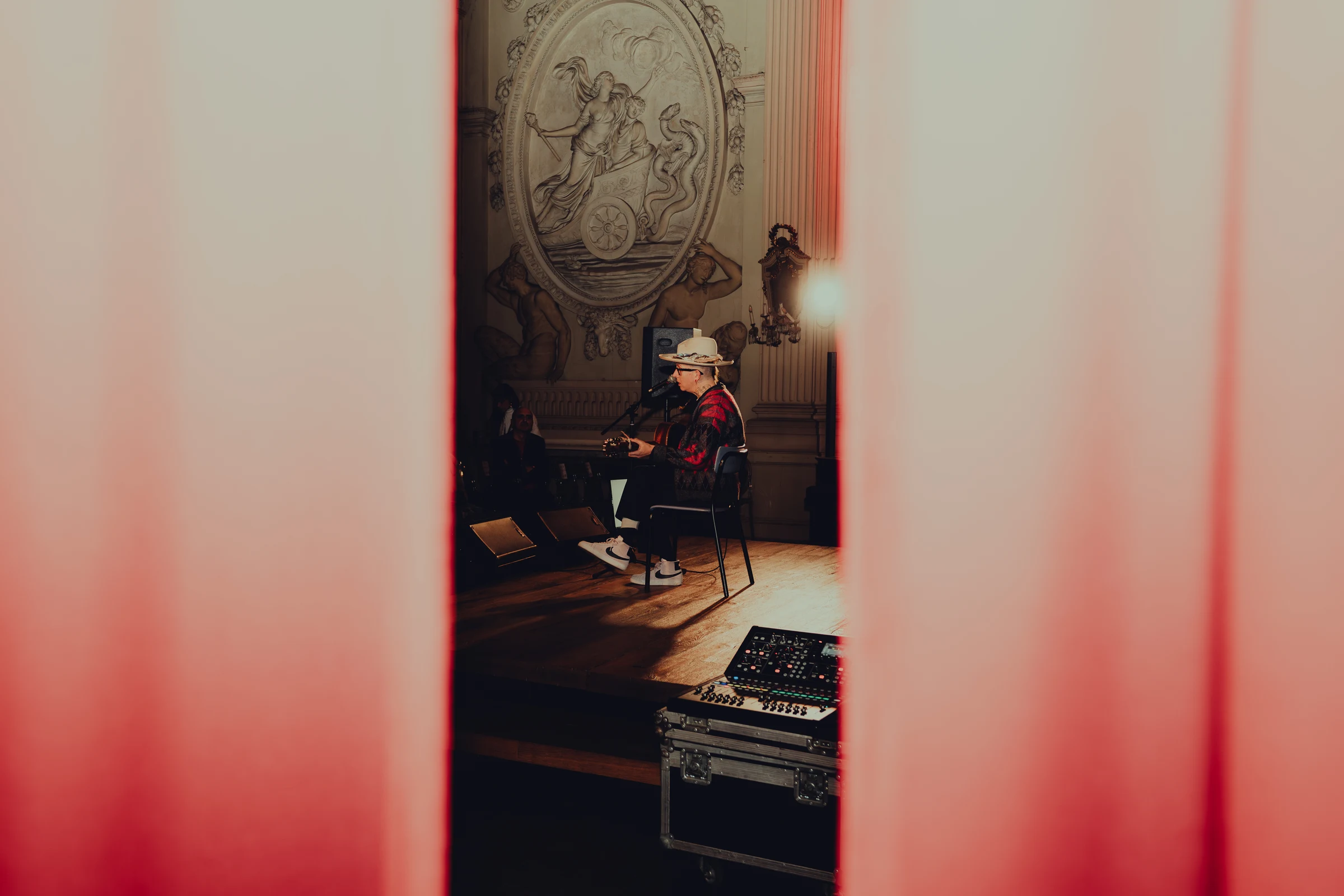 Musician playing guitar in a historic hall