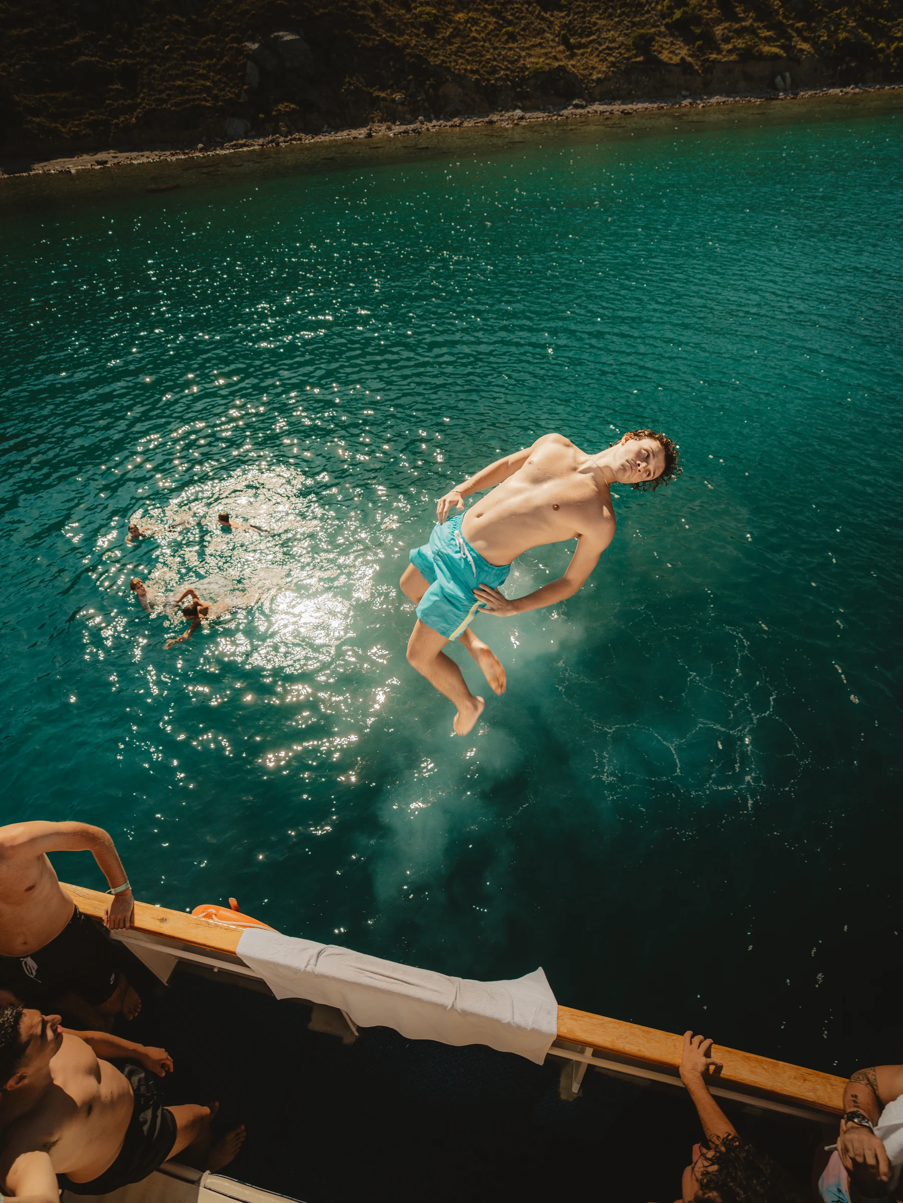 Diver rotating above an outdoor swimming pool