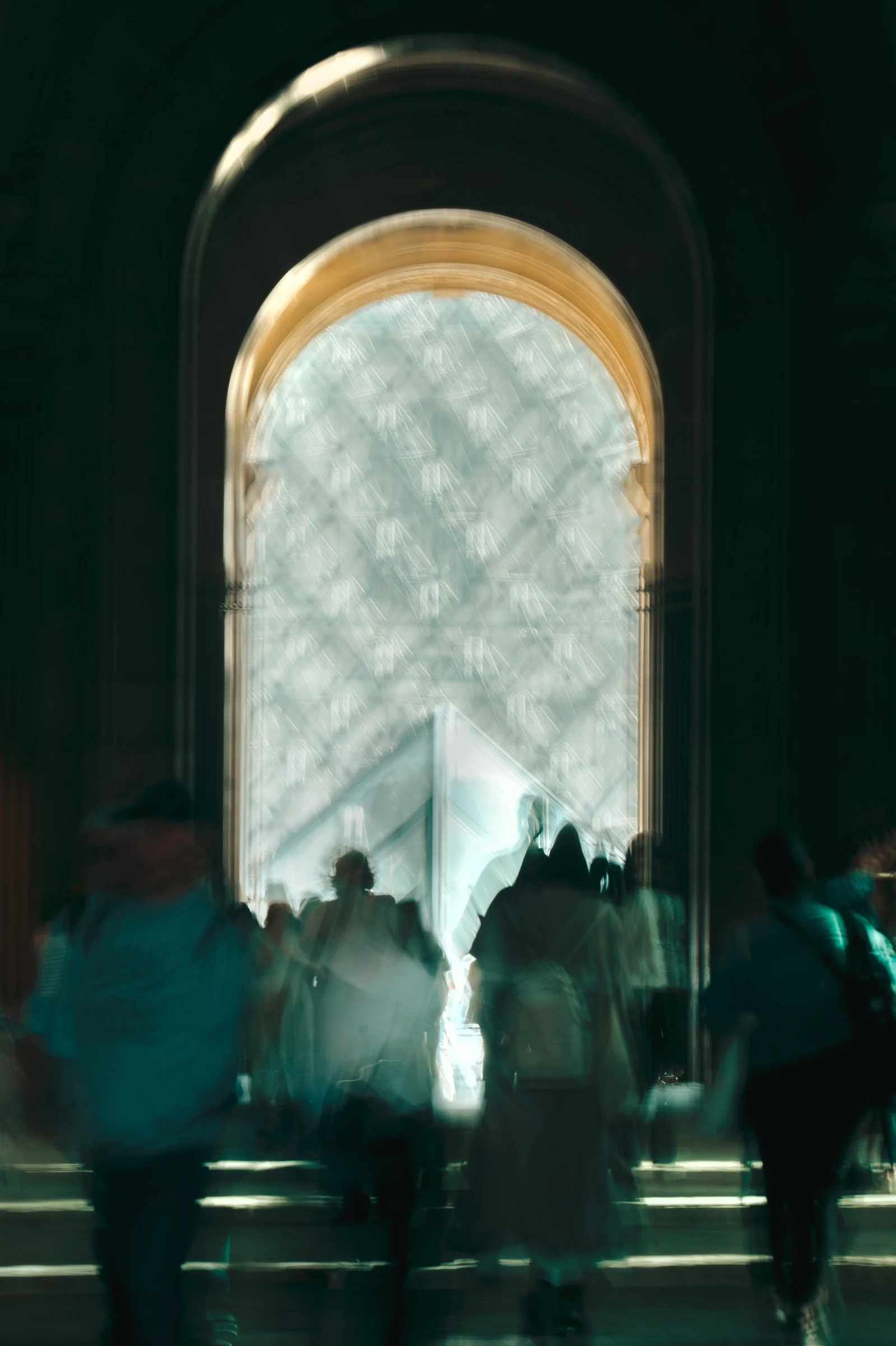 Silhouettes gathered beneath a tall arched window
