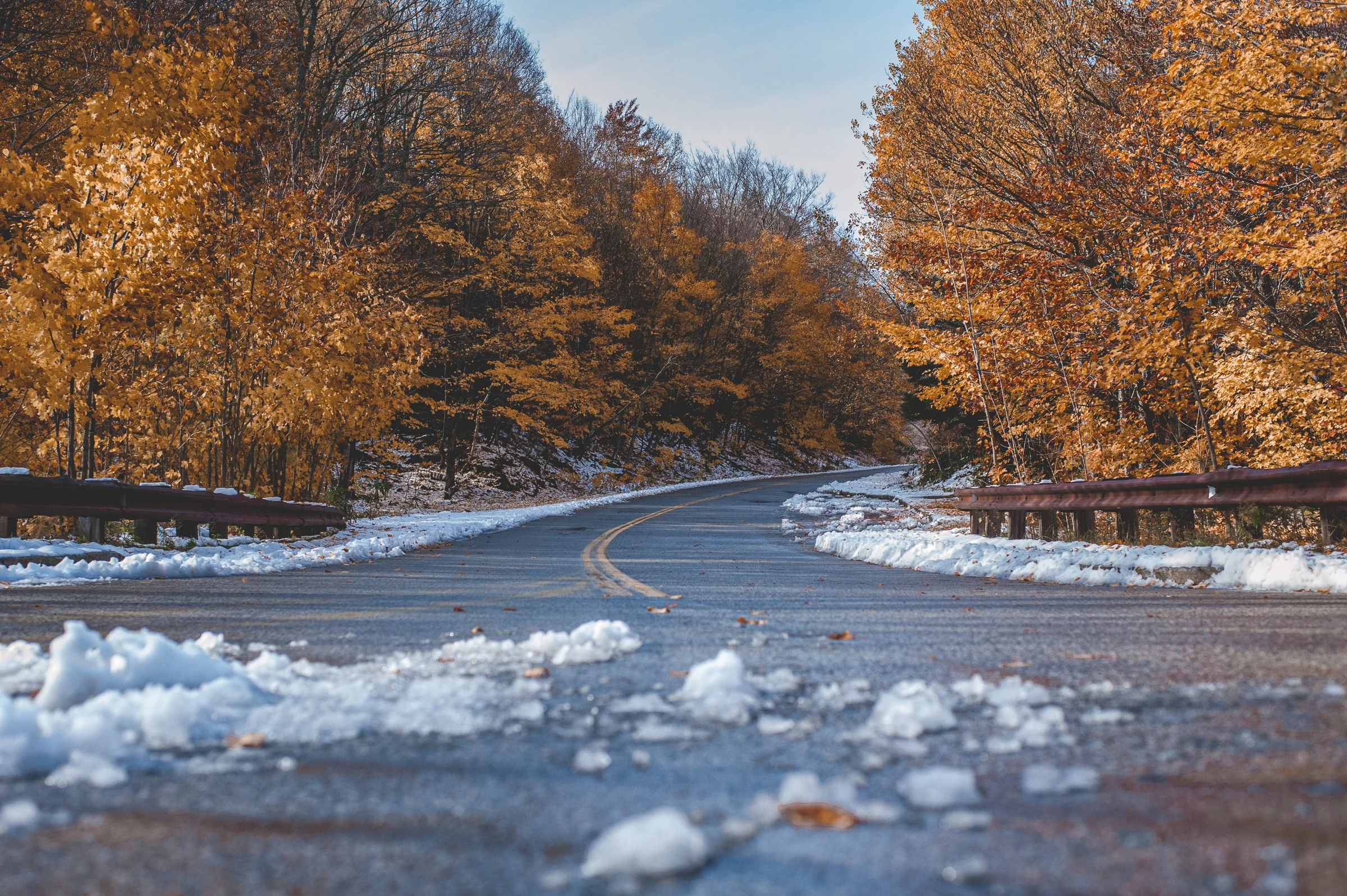 Winding road through an autumn forest after the first snow